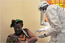  ?? CELLOU BINANI/AFP/GETTY IMAGES FILES ?? A woman gets vaccinated at a health centre in Conakry, Guinea, during the first clinical trials of the rVSV-ZEBOV vaccine against the Ebola virus in March.