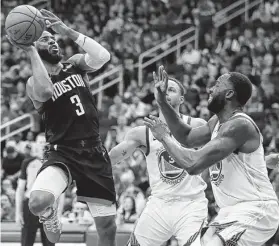  ?? Photos by Brett Coomer / Staff photograph­er ?? Rockets guard Chris Paul (3) has to adjust his shot as the Warriors’ Stephen Curry, center, and Draymond Green close in.