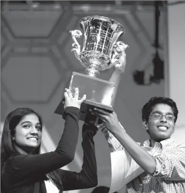  ?? Associated Press ?? Vanya Shivashank­ar, 13, left, of Olathe, Kan., and Gokul Venkatacha­lam, 14, of St. Louis, hold up the trophy as co-champions after winning the finals of the Scripps National Spelling Bee Thursday in Oxon Hill, Md.