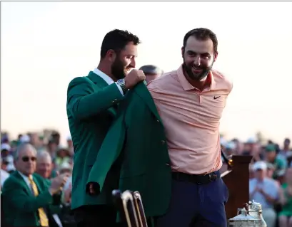  ?? ?? Scottie Scheffler is presented with his first green jacket by last year’s champion Jon Rahm at Augusta