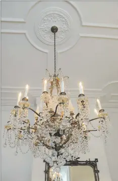  ??  ?? Some of the home’s elegant features include this chandelier and detailed mouldings.