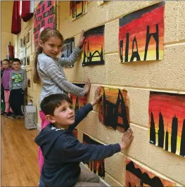  ??  ?? Hanging their artworks on the walls at Ballyfinna­ne National School.