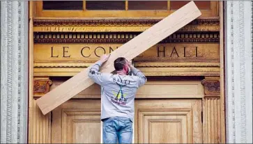  ?? I rene Yi UC Berkeley ?? A UC BERKELEY worker uses an oak plank to cover up the words on LeConte Hall, named after founding faculty members John and Joseph LeConte — scholars who also promoted racist rhetoric and colonialis­t ideas.