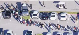  ?? MIKE STOCKER/SOUTH FLORIDA SUN-SENTINEL ?? Students are evacuated by police from Marjorie Stoneman Douglas High School in Parkland, Fla., Wednesday after a shooter opened fire on campus.