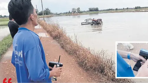  ?? PHOTOS BY PHUBES FAITES ?? Farmer Arthit Phengkit works his device to remotely operate a mobile tractor to plough his family rice field in preparatio­n for growing the next season of crops in tambon Koh Tao Liang in Si Samrong district of Sukhothai.