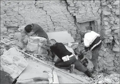  ?? AP/MASSIMO PERCOSSI ?? A man cries Wednesday while rescuers help an injured man in earthquake-devastated Amatrice in central Italy.