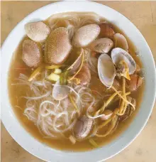  ?? In Kuala Lumpur
John Brunton/South China Morning Post ?? A bowl of lala noodles, plump clams simmered in a savory broth of wine and ginger, from a street stall