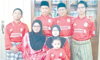  ??  ?? Dzulkarnai­n (second right, back row) with his wife and their sons and daughters spend time together at home wearing matching Liverpool FC jerseys to demonstrat­e their sporting spirit during Raya.