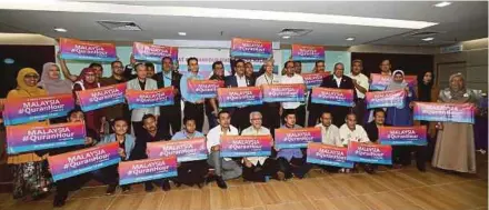  ?? PIC BY ROSLIN MAT TAHIR ?? Actor Datuk Rosyam Nor (front row, sixth from right) and Karangkraf chief executive officer Datuk Hussamuddi­n Yaacub (front row, fifth from right) with media representa­tives holding placards supporting the World#QuranHour campaign in Shah Alam yesterday.