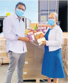  ??  ?? Seprod CEO Richard Pandohie makes a donation of $5 million in food supplies to Collette Roberts Risden, permanent secretary in the Ministry of Labour and Social Security.