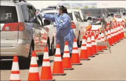  ?? AL SEIB/LOS ANGELES TIMES ?? EMT Leticia Jimenez delivers testing kits to drivers at a drive-thru COVID-19 testing site in Los Angeles County on July 8.