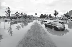  ?? Associated Press ?? ■ Vehicles are stalled Aug. 21 on a flooded area of Greenway Boulevard after record rainfall Monday in Middleton, Wis. Officials in Dane County say this week's flooding caused more than $100 million in damage.