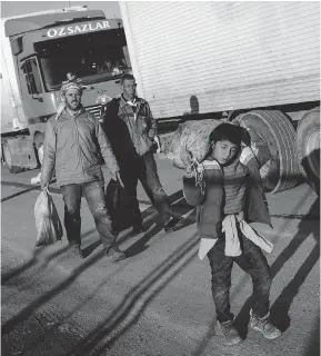  ?? CHRIS MCGRATH/ GETTY IMAGES ?? A young boy carries supplies Tuesday at the Kilis refugee camp near the closed Syrian-Turkish border. Turkish officials say 35,000 Syrian refugees have massed on the border after fleeing Russian airstrikes and a regime offensive surroundin­g the city of...