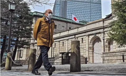  ?? ?? A man walks past the Bank of Japan headquarte­rs complex in
Tokyo. The
BOJ yesterday decided to end its negative interest rate policy with its first rate hike in 17 years.
— AFP