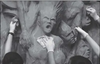  ?? ASSOCIATED PRESS ?? University students clean the “Pillar of Shame” statue, a memorial for those killed in the 1989 Tiananmen crackdown, at the University of Hong Kong, June 4, 2019.