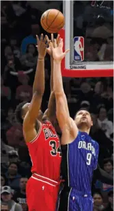  ?? DAVID BANKS/AP ?? Bulls big man Wendell Carter Jr., who didn’t score Wednesday, and Magic center Nikola Vucevic battle for a rebound in the first half.