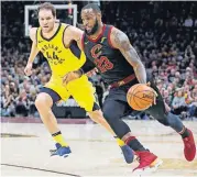  ?? [TONY DEJAK/THE ASSOCIATED PRESS] ?? Cleveland’s LeBron James, right, drives past Indiana’s Bojan Bogdanovic during the first half of Game 7, Sunday in Cleveland.