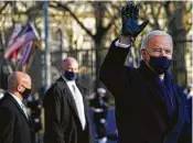  ?? Drew Angerer / Getty Images ?? Left, Biden walks an abbreviate­d parade route after taking the oath of office Wednesday.