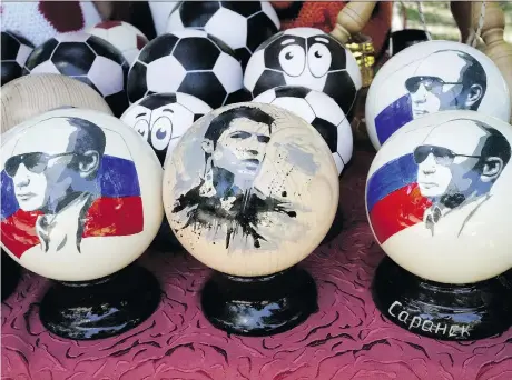 ?? THE ASSOCIATED PRESS ?? Balls depicting Russian President Vladimir Putin are selling as souvenirs alongside others bearing an image of Cristiano Ronaldo.