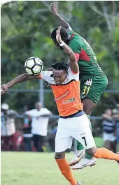  ?? FILE ?? Orrette Richards of Dunbeholde­n gets hit in the back by Humble Lion captain Hugh Howell while duelling for an aerial ball during their Red Stripe Premier League encounter at the Effortvill­e Community Centre on Sunday, October 21, 2018.