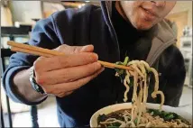  ?? AP PHOTO ?? A man uses chopsticks to eat noodles at a restaurant in Beijing in 2003. The stirring of noodles or any sort of slimy food, foam and other “things that make squishy, slimy sounds” are widely reported to stimulate ASMR, according to Dr. Craig Richard.