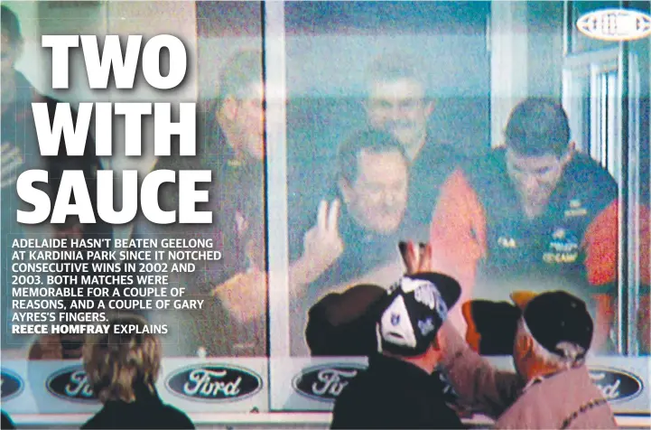  ?? . ?? TWO-PRONGED ATTACK: Gary Ayres, John Reid, Neil Craig and Darren Jarman exchange two-finger salutes with a Geelong fan at Kardinia Park on July 28, 2002.