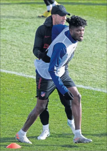  ??  ?? Simeone sujeta a Thomas ayer, en la sesión del Atlético en el Cerro del Espino durante un ejercicio.