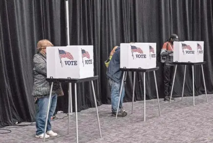  ?? SETH HERALD/AFP VIA GETTY IMAGES ?? People cast their votes in Lansing, Michigan, on Nov. 3, 2020.