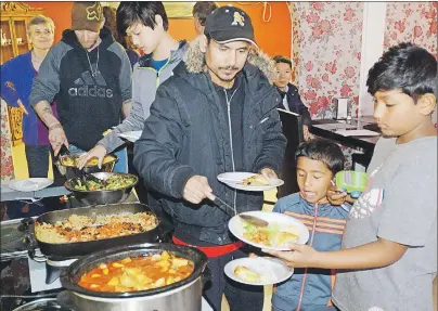  ?? MITCH MACDONALD/THE GUARDIAN ?? Grafton Street residents, from right, Arun, Arjun and Deepak Darjee, get some food during a community meal at Sadat’s Cuisine on Saturday night. The meal was what many tenants felt would be the final opportunit­y to all get together after receiving...