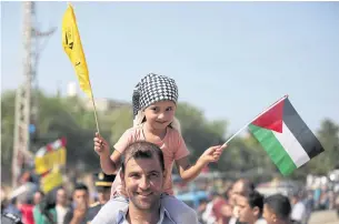  ??  ?? Palestinia­ns gather at the Erez crossing in the northern Gaza Strip to welcome the arrival of Palestinia­n Prime Minister Rami Hamdallah and his government yesterday.