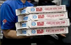  ?? Andrew Harrer/ Bloomberg ?? A employee moves pizza boxes before a delivery at a Domino’s Pizza Inc. restaurant in Chantilly, Va. The pizza chain’s stock fell 8.7% on Tuesday.