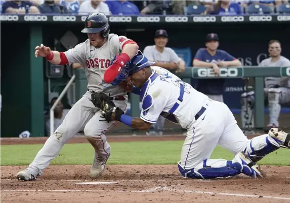  ?? Getty imageS; Below, ap ?? NAILED: Christian Arroyo is tagged out by Kansas City catcher Salvador Perez on a fielder’s choice in the third inning at Kauffman Stadium on Friday night in Kansas City. Below, starter Nick Pivetta throws during the fifth inning.