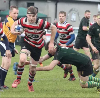  ??  ?? Enniscorth­y lock Tomás Stamp, scorer of two tries, evades a tackle by Paul Kelly of Boyne.