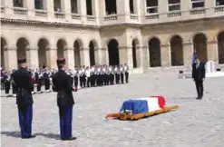  ??  ?? PARIS: French President Emmanuel Macron (right) stands in front of the flag-draped coffin of Simone Veil during a solemn funeral ceremony, in the courtyard of the Invalides in Paris yesterday. — AP