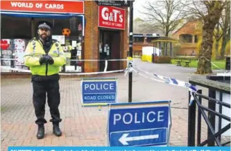  ?? —AFP ?? SALISBURY: A police officer stands on duty at a cordon near a bench covered in a protective tent at The Maltings shopping centre in Salisbury, southern England, where a man and woman were found critically ill on March 4, after being apparently poisoned...