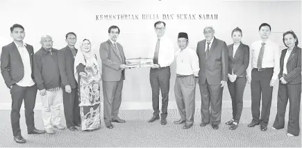  ??  ?? Dr Charanjit (5th left) presenting a memento to Poon (centre) while Awang Damit (5th right), Avtar (4th right) and others look on.