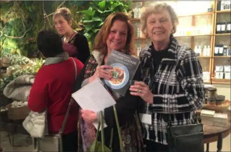  ?? PEG DEGRASSA - DIGITAL FIRST MEDIA ?? Tara Snyder of Aston and her mother, Diane Keeley of Media, both fans of Martha Stewart, hold up the author’s new book ‘Martha Stewart’s Pressure Cooker,’ during a special cocktail party at Terrain in Glen Mills.