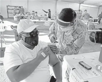  ?? SUSAN STOCKER/SOUTH FLORIDA SUN SENTINEL ?? Thomas Nelson, 51, of Miami Gardens, receives his first dose of the Pfizer COVID-19 vaccine at the FEMA-supported site at Miami Dade College North on Monday.