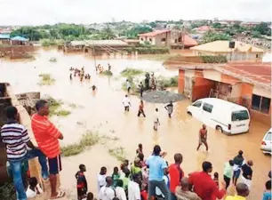  ?? People ?? wade through a flooded street