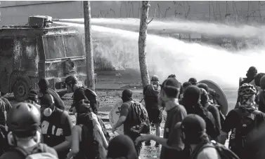  ??  ?? RIOT police spray water to disperse demonstrat­ors during a protest against Chilean President Sebastian Pinera’s government in Santiago, on January 17, 2020. Chile has been rocked by three months of protests that began with strikes over metro fare hikes and quickly escalated into the most severe outbreak of social unrest since the end of the dictatorsh­ip of Augusto Pinochet nearly 30 years ago.
MARTIN BERNETTI / AFP