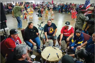  ??  ?? ABOVE: Northern Eagle Singers sing and drum as dancers participat­e in the grass dance during the Yuba-sutter Winter Pow Wow at the Allyn Scott Youth and Community Center on Saturday in Marysville. LEFT: Event emcee Val Shadowhawk, left, talks with...