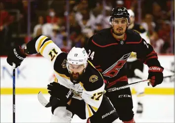  ?? Jared C. Tilton / Getty Images ?? The Bruins’ Nick Foligno and the Hurricanes’ Seth Jarvis skate during the second period in Game 7 of a first-round playoff series on Saturday.