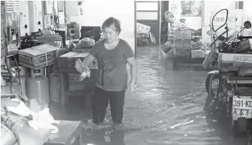  ??  ?? Local residents stay in their flooded home during heavy rain in Jinshan, New Taipei City.