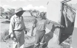  ??  ?? Mr Russell Ndlovu shows Councillor Abednico Maphosa one of the three huts gutted by mysterious fires at his homestead in Bona area, Bubi District on Thursday. Pic by Fortunate Muzarabani