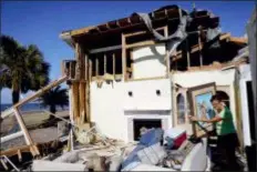  ?? DAVID GOLDMAN — THE ASSOCIATED PRESS ?? Marla Wood pulls a framed art piece out of the rubble of her damaged home from Hurricane Michael in Mexico Beach, Fla., Sunday.