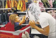  ?? Brynn Anderson / Associated Press ?? Liam Vasquez, 2, and his father, Will Vasquez try on masks at Target on Wednesday in Pembroke Pines, Fla.