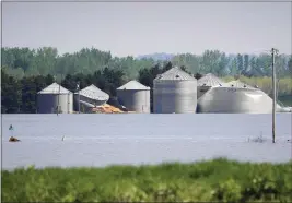  ?? NATI HARNIK — THE ASSOCIATED PRESS ?? Grain bins belonging to Brett Adams are surrounded by flood waters, in Peru, Neb.