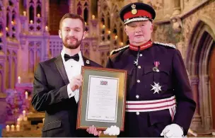  ??  ?? Cadet warrant officer Michael Wild, from Bramhall, receives his award from Warren Smith, Lord Lieutenant of Greater Manchester.