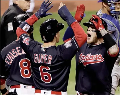  ?? AP/GENE J. PUSKAR ?? Cleveland catcher Roberto Perez (right) is greeted by teammates Brandon Guyer (center) and Lonnie Chisenhall after hitting his second home run Tuesday night to power the Indians past the Chicago Cubs 6-0 and grab a 1-0 lead in the World Series.