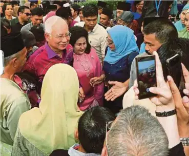  ?? PIC BY FARIZ ISWADI ISMAIL ?? Prime
Minister Datuk Seri Najib Razak and his wife, Datin Seri Rosmah Mansor, at the National Civics Bureau’s Hari Raya Aidilfitri open house in Kuala
Lumpur yesterday.